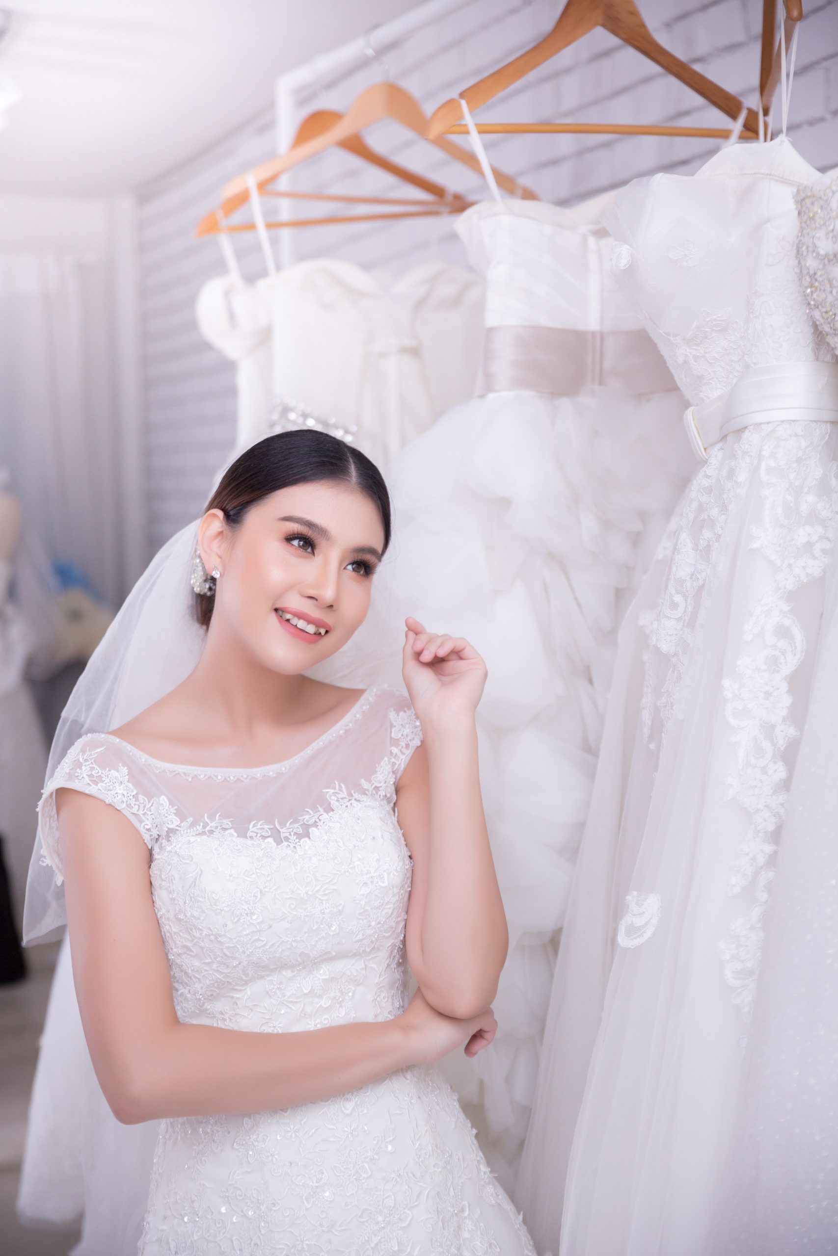 Asian young woman bride trying on wedding dress at modern wedding